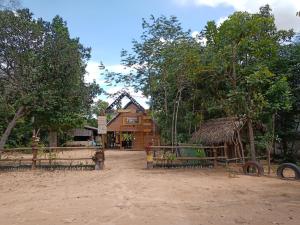 a building in the middle of a dirt field at Refúgio Raiz Camping in Carolina