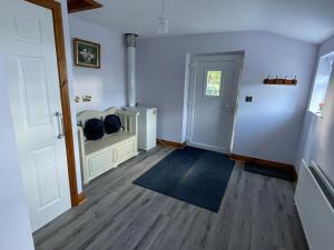 um quarto com um corredor com uma porta e um tapete em Rose Cottage em Cullybackey