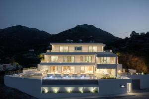 a large white house with lights on it at night at Ode Iconic Residence, forever in blue - Best Villa, By ThinkVilla in Bali