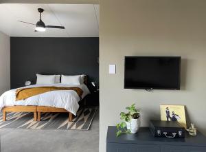 a bedroom with a bed and a flat screen tv at The Goodland Cottages in Champagne Valley