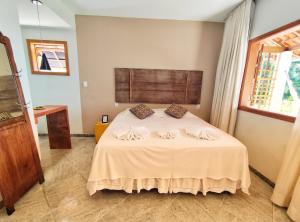 a bedroom with a bed with two pillows on it at Pousada Villa Magna - Chalé in Diamantina