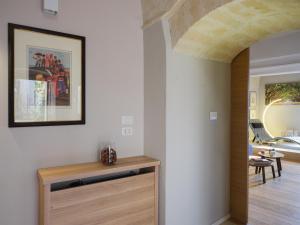 una habitación con un pasillo con una mesa y una pintura en la pared en SaxAurea, en Matera