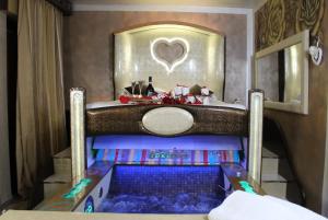 SPA B&B Roma D'Autore Il Nido d'Amore في روما: غرفة نوم مع سرير مع حوض ومرآة