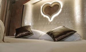 łóżko z dwoma poduszkami i sercem na ścianie w obiekcie SPA B&B Roma D'Autore Il Nido d'Amore w Rzymie