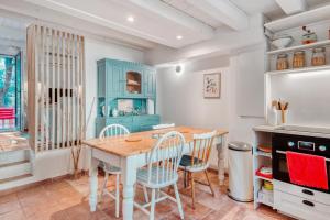 uma cozinha com uma mesa de madeira e cadeiras em Traditional house in a calm residence in Sanary-sur-Mer - Welkeys em Sanary-sur-Mer