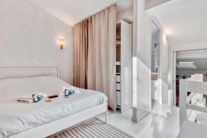 um pequeno quarto com uma cama branca e uma escada em Traditional house in a calm residence in Sanary-sur-Mer - Welkeys em Sanary-sur-Mer