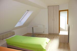 ein Schlafzimmer mit einem grünen Bett und einer Treppe in der Unterkunft Malina in Vransko
