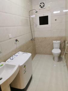 ein Badezimmer mit einem weißen WC und einem Waschbecken in der Unterkunft شقق الشاطئ in Al Qunfudhah