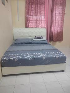 Bett in einem Schlafzimmer mit rosa Vorhängen in der Unterkunft Homestay Tengku Maheran in Jitra