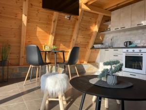 Rakari的住宿－Cool House and Pool, Banja Vrujci，厨房配有2张桌子和椅子以及炉灶。