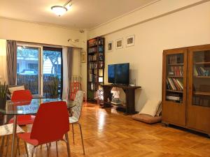 een woonkamer met een tafel en stoelen en een televisie bij Acropolis in Athene