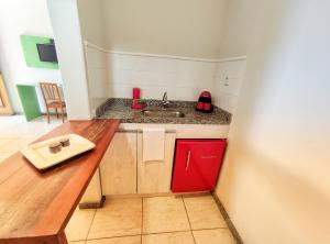 a small kitchen with a sink and a red cabinet at Pousada Villa Magna - Chalé in Diamantina