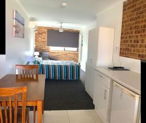 A bed or beds in a room at Golden Beach Motor Inn, Caloundra