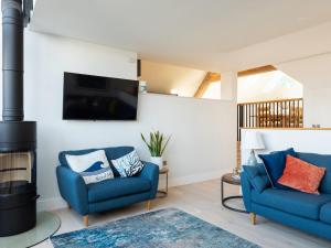 un salon avec deux chaises bleues et une cheminée dans l'établissement Church Rooms, à Port Isaac