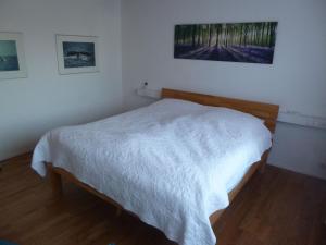 um quarto com uma cama com um cobertor branco em Ferienhaus Unteres Hart em Gomadingen