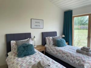 deux lits côte à côte dans une chambre dans l'établissement Willow Cottage at Gravel Farm, à Stretham