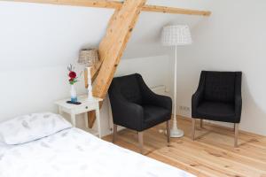 a bedroom with two chairs and a bed and a lamp at B&B De Kreek in Graauw
