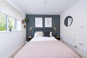 a bedroom with a large bed and two windows at Stratford-Upon-Avon Luxury Snug with Free Parking in Stratford-upon-Avon