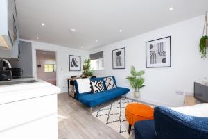 a kitchen and a living room with a blue couch at Stratford-Upon-Avon Luxury Snug with Free Parking in Stratford-upon-Avon