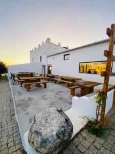 a group of wooden picnic tables and a large rock at Quinta do Castelo in Beja