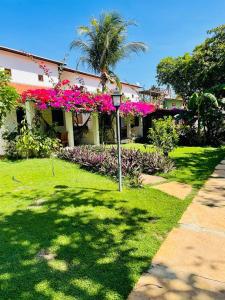 a house with pink flowers and a street light at Pousada Villa Caju in Jericoacoara
