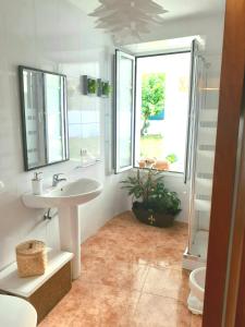 a bathroom with a sink and a toilet and a window at Apartamento entero con jardín en Casa Amelia in Padrón