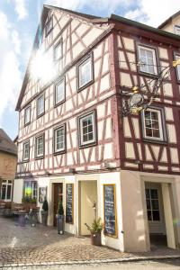 abered building with a sign in front of it at Jäger's Landhaus Rössle in Niedernhall