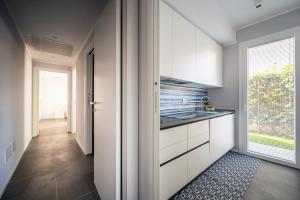 eine Küche mit weißen Schränken und einem Fenster in der Unterkunft Appartamento Maestrale in Riccione