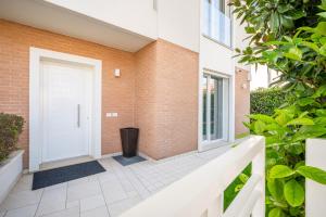 ein Backsteinhaus mit einer weißen Tür und einem Innenhof in der Unterkunft Appartamento Maestrale in Riccione