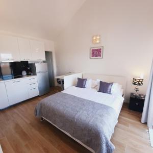 a bedroom with a large bed and a kitchen at Apartments Marti in Murter