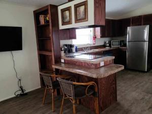 a kitchen with a counter with chairs and a refrigerator at The Villa - Amazingly Comfortable King Beds in Alpine +10 photos