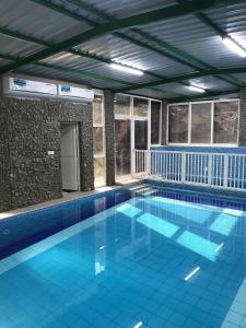 a large swimming pool with blue tiles in a building at استراحة المعمورة Al maamoura Retreat in Hatta