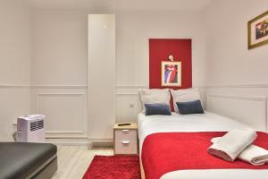 sypialnia z łóżkiem i czerwonym dywanem w obiekcie 68 - The Rolling Stones Flat w Paryżu