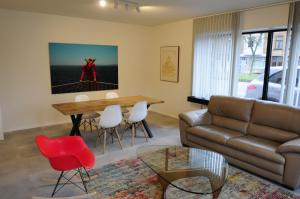 ein Wohnzimmer mit einem Sofa, einem Tisch und Stühlen in der Unterkunft ABC Boutique Apartments in Brügge
