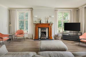a living room with a fireplace and a tv at Beautiful English Villa with hottub in Zuidwolde