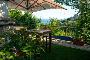 a wooden table and an umbrella on a balcony at Residence Zelzar in Vietri sul Mare