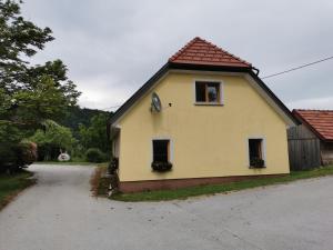 ein gelbes Haus mit zwei Fenstern an einer Straße in der Unterkunft Malina in Vransko