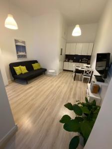 uma sala de estar com um sofá preto e uma cozinha em Apartamenty Sobieski em Sopot