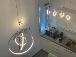 a kitchen with a bunch of lights hanging from the ceiling at Miranda, Modern Duplex, Garden, Swimming Pool, Parking in Losone