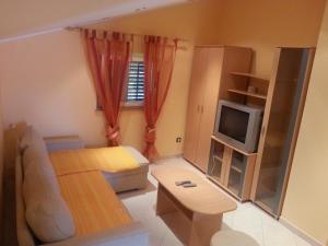 una pequeña sala de estar con sofá y TV en Apartment Toni en Labin