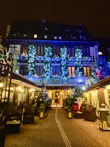 a building with christmas lights on it at night at Hotel Restaurant Le Maréchal - Les Collectionneurs in Colmar