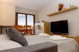a living room with two beds and a flat screen tv at Apartamento Besiberri Vielha in Vielha