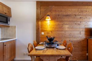 une table en bois dans une cuisine avec un mur en bois dans l'établissement Les Alpages du Corbier A003, au Corbier