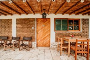 a patio with a wooden door and chairs and a table at Hotel Culturpisco in Ica