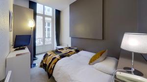 Un pat sau paturi într-o cameră la Hotel du Théâtre
