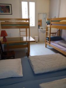 若西耶Maison familiale des Gueyniers的客房设有几张双层床和一张书桌。