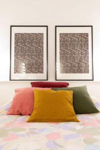 ein Schlafzimmer mit zwei Bildern an der Wand und einem Bett in der Unterkunft le Tillot in Dijon