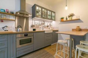 eine Küche mit grauen Schränken und einer hölzernen Arbeitsplatte in der Unterkunft le Tillot in Dijon