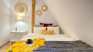 ein Schlafzimmer mit einem Bett mit einer gelben Decke darauf in der Unterkunft Wroclaw Inn Apartments in Breslau