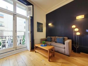 a living room with a couch and a table at Thames Residences Hyde Park in London